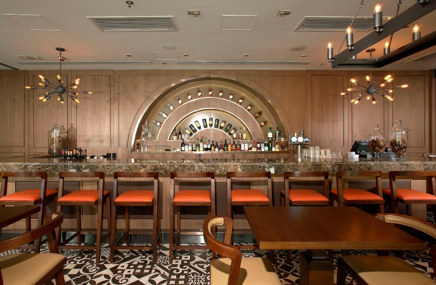restaurant bar full of wood details and bright patterns by J Candice Interior Architects: Dramatic Yet Opulent Designs